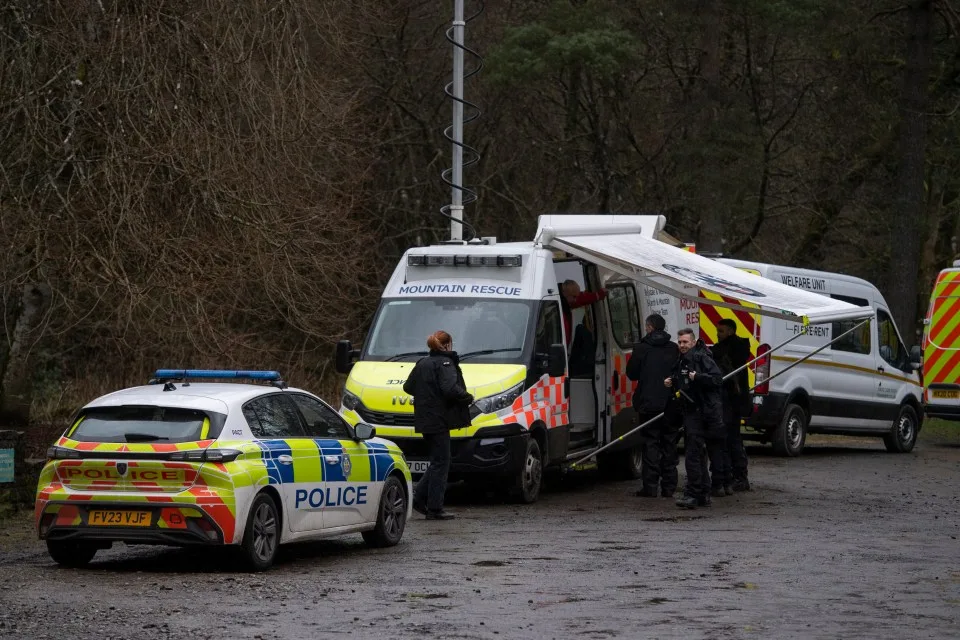 Les véhicules de sauvetage de police et de montagne sur un site de recherche.